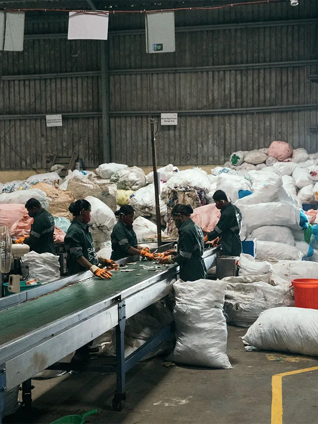 Fünf Personen arbeiten in einer Recyclinganlage (Foto)